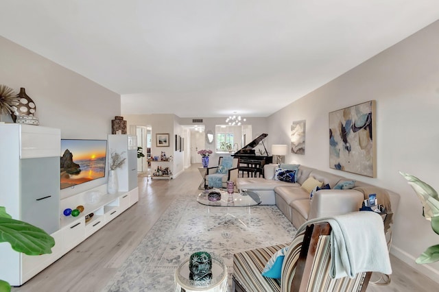 living room with a notable chandelier and light hardwood / wood-style floors