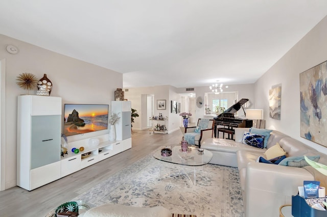 living room with hardwood / wood-style floors and a notable chandelier