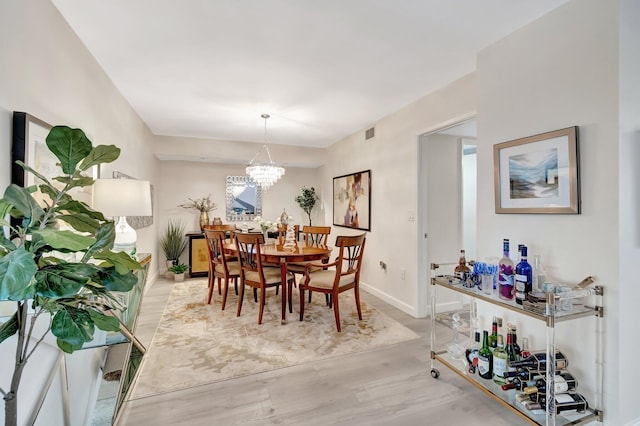 dining area with hardwood / wood-style floors and a chandelier