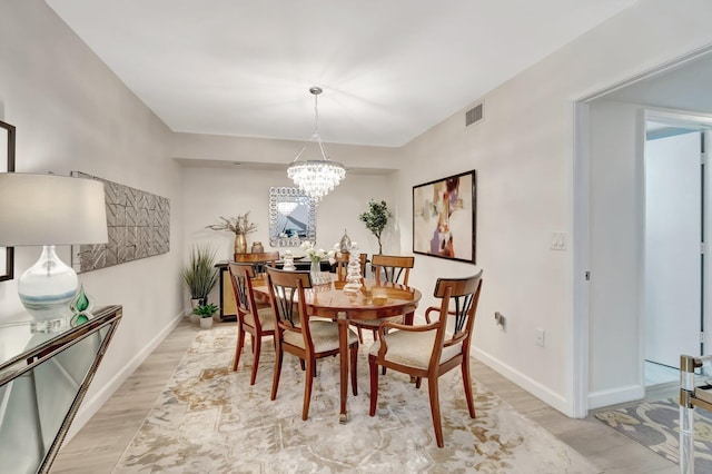 dining room with a chandelier and light hardwood / wood-style floors