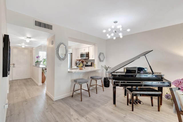 misc room with a chandelier and light hardwood / wood-style floors