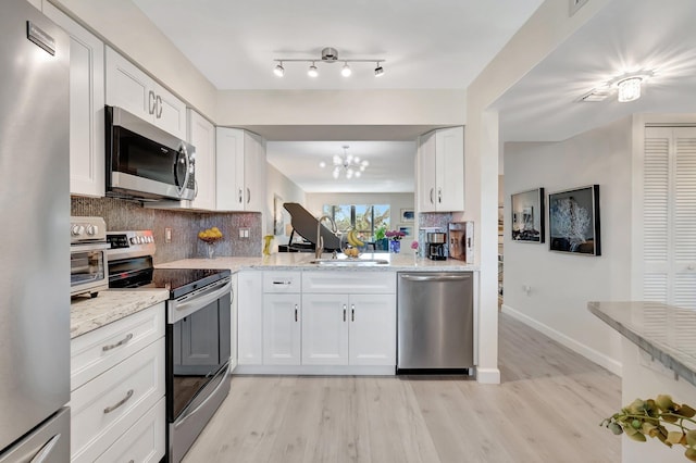 kitchen featuring backsplash, appliances with stainless steel finishes, light stone countertops, and white cabinets