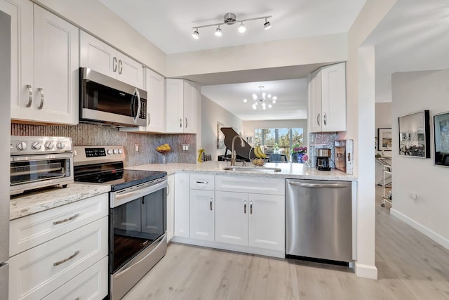 kitchen featuring stainless steel appliances, sink, white cabinets, and backsplash