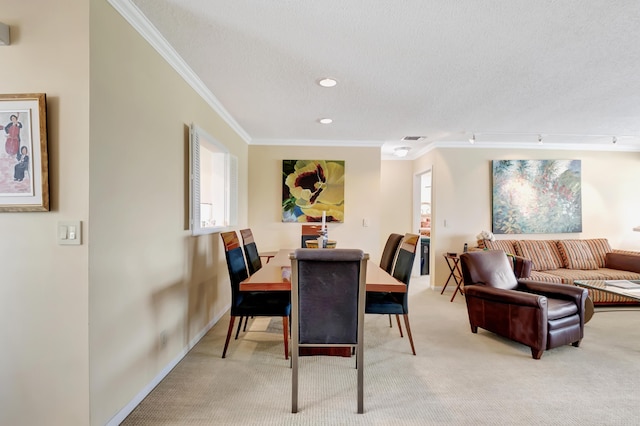 dining area featuring crown molding, rail lighting, a textured ceiling, and carpet