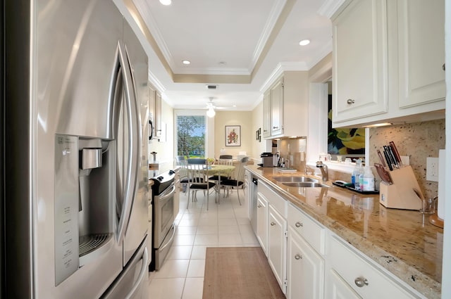 kitchen with light tile patterned flooring, sink, crown molding, stainless steel appliances, and white cabinets