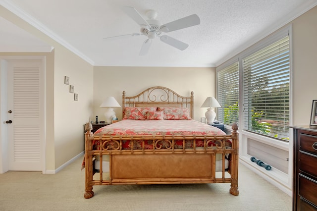 bedroom featuring crown molding, light carpet, ceiling fan, and a textured ceiling