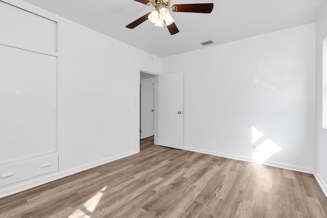 unfurnished bedroom with ceiling fan, light wood-type flooring, and a closet