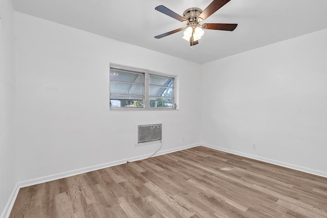 unfurnished room featuring an AC wall unit, ceiling fan, and light wood-type flooring