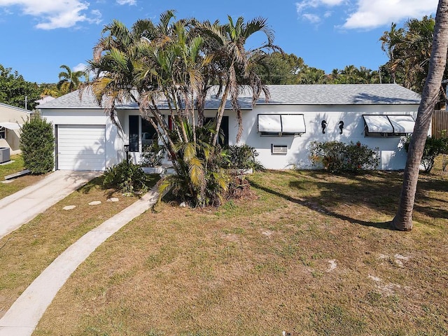 view of front facade with central AC unit, a garage, and a front yard