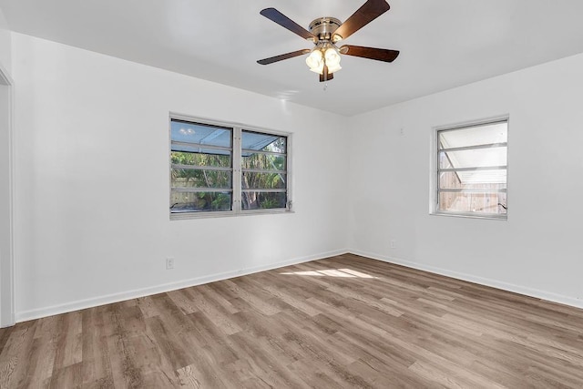 spare room with ceiling fan, light wood-type flooring, and a wealth of natural light