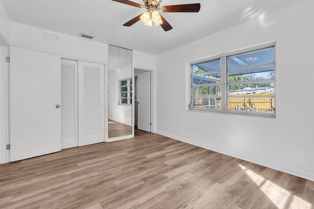 unfurnished bedroom with light hardwood / wood-style floors, a closet, and ceiling fan