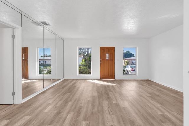 interior space featuring a textured ceiling and light hardwood / wood-style flooring