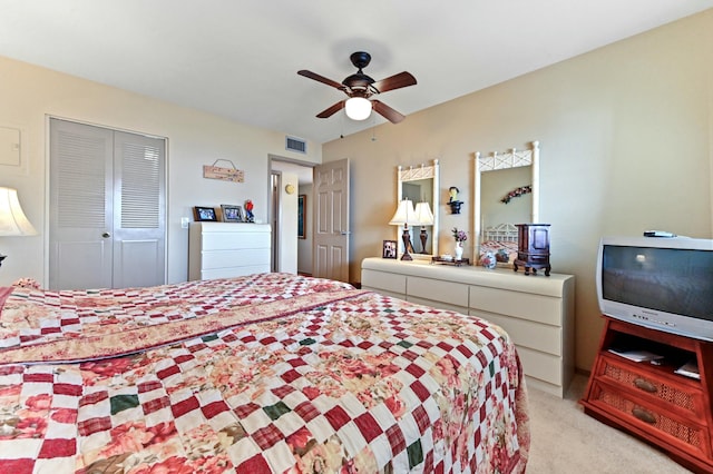 bedroom with ceiling fan, a closet, and light carpet