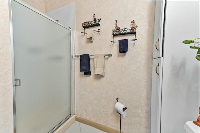 bathroom featuring a shower with door