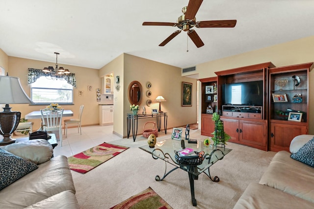 tiled living room with ceiling fan with notable chandelier