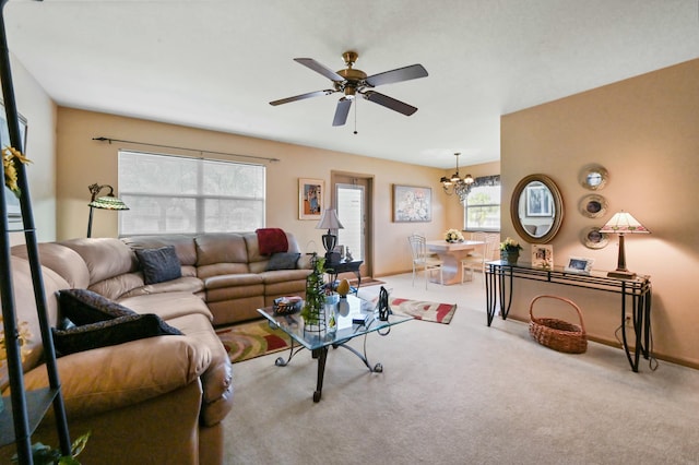 living room with ceiling fan with notable chandelier and light carpet