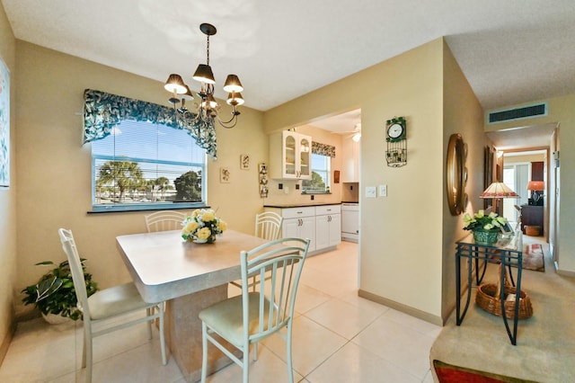 tiled dining area with a notable chandelier and plenty of natural light