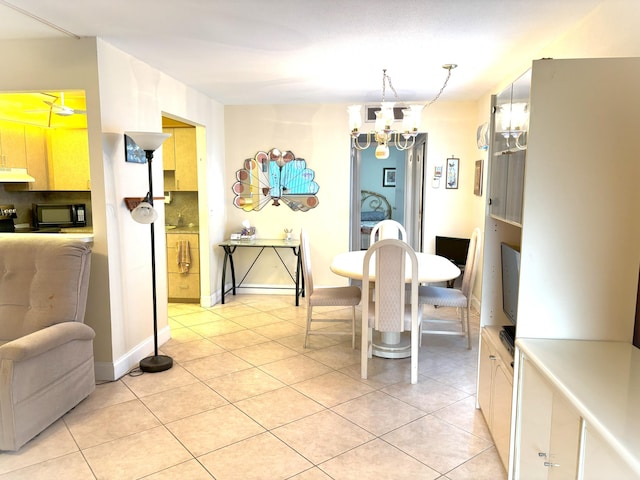 dining area with light tile patterned floors and an inviting chandelier