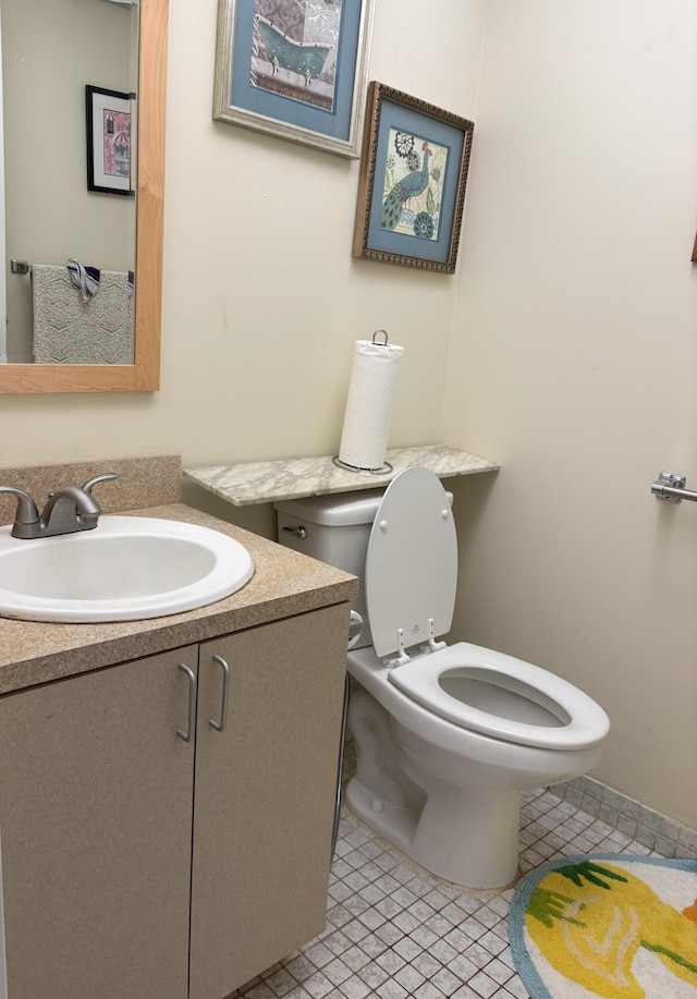 bathroom featuring vanity, tile patterned flooring, and toilet