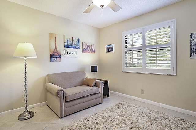 sitting room with light tile patterned floors, a textured ceiling, and ceiling fan