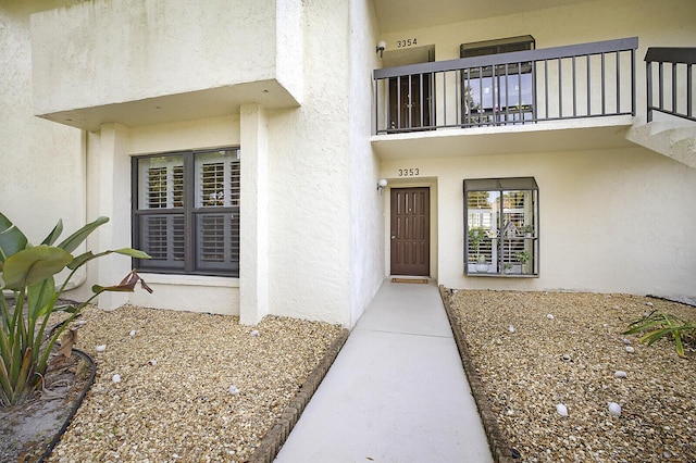 view of exterior entry featuring a balcony