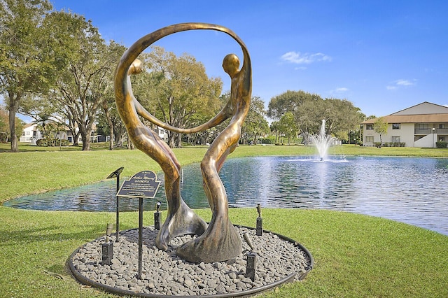 view of community with a water view and a lawn