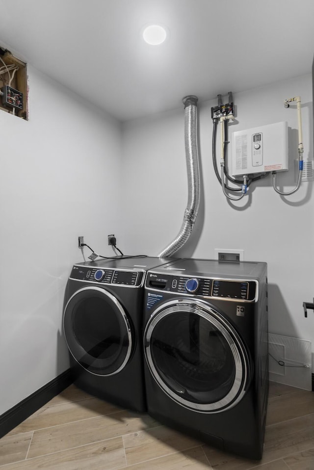 clothes washing area with light wood-type flooring and washer and clothes dryer