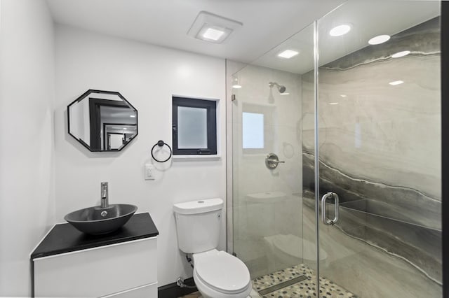 bathroom with walk in shower, vanity, and toilet