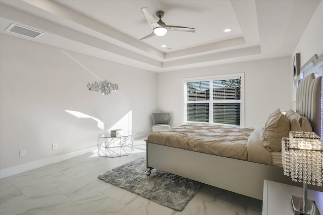 bedroom with ceiling fan and a raised ceiling