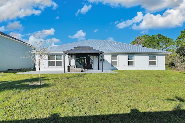 back of property with a gazebo, a patio area, and a lawn