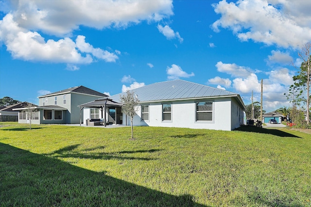 back of house with a gazebo and a yard