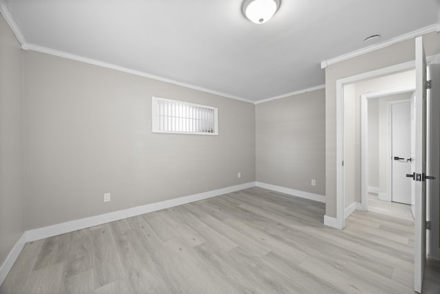 empty room with ornamental molding and light hardwood / wood-style floors