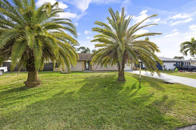 ranch-style home featuring a garage and a front lawn