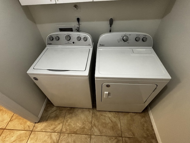 clothes washing area with laundry area, washer and clothes dryer, and baseboards