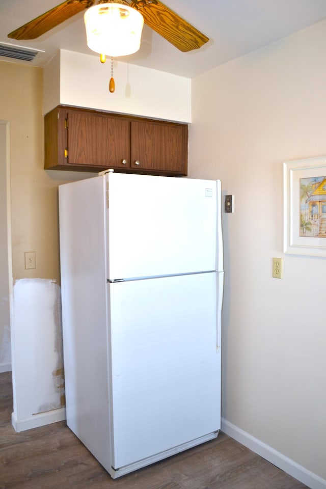 kitchen with dark hardwood / wood-style flooring, ceiling fan, and white fridge