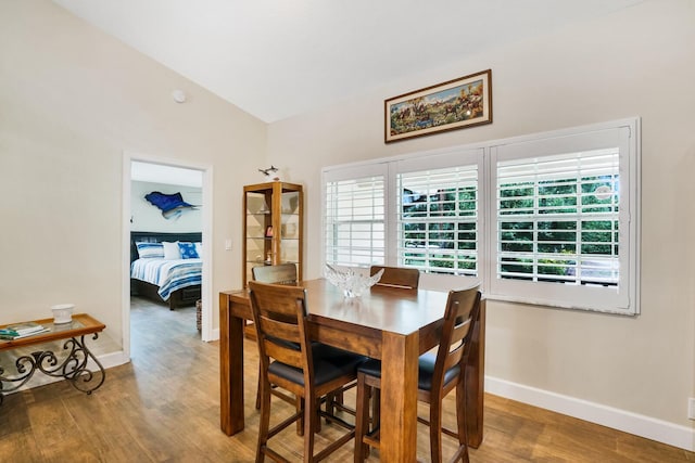 dining area with lofted ceiling and wood-type flooring