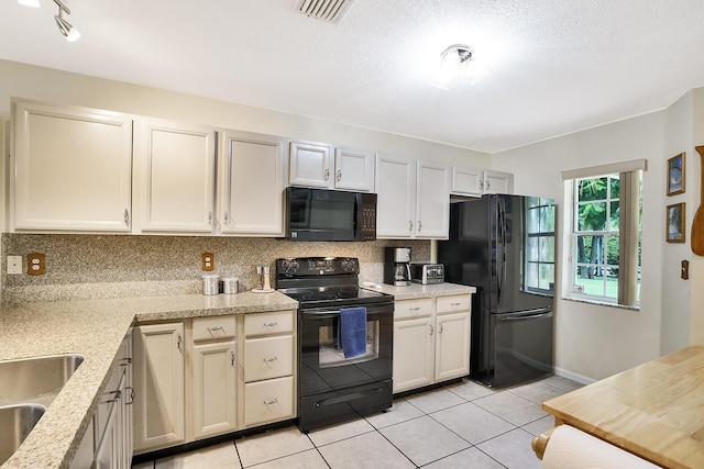 kitchen featuring light tile patterned flooring, sink, backsplash, black appliances, and a textured ceiling