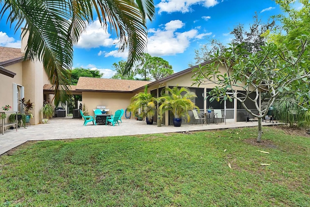 rear view of house with a sunroom, a yard, central air condition unit, and a patio area