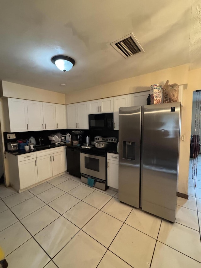 kitchen featuring white cabinetry, sink, light tile patterned floors, and black appliances