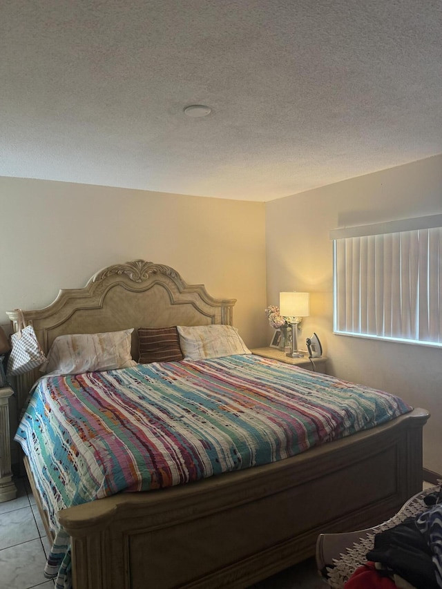 tiled bedroom featuring a textured ceiling