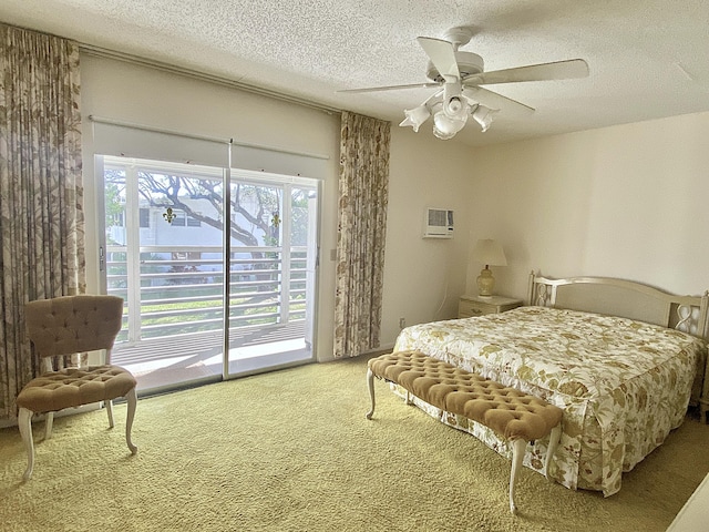 bedroom featuring a textured ceiling, carpet flooring, a wall unit AC, ceiling fan, and access to exterior