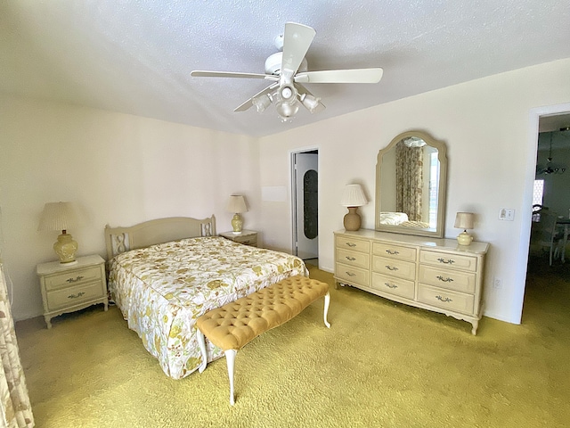 carpeted bedroom with ceiling fan and a textured ceiling