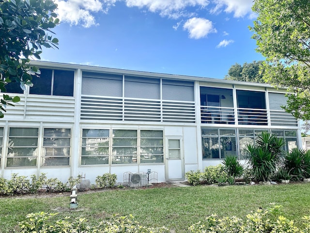 back of house featuring a lawn