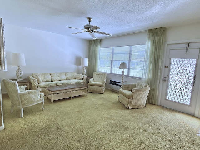 carpeted living room with ceiling fan and a textured ceiling