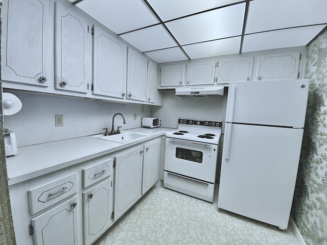 kitchen with sink, a paneled ceiling, and white appliances