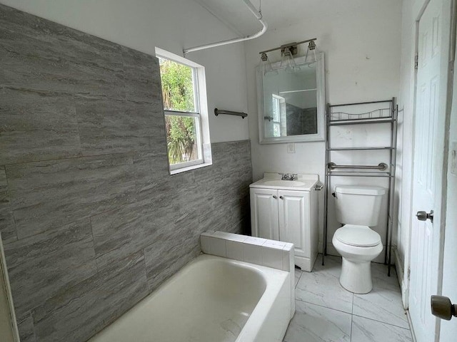 bathroom featuring vanity, a tub, and toilet