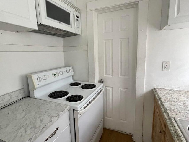 kitchen with white appliances and white cabinets