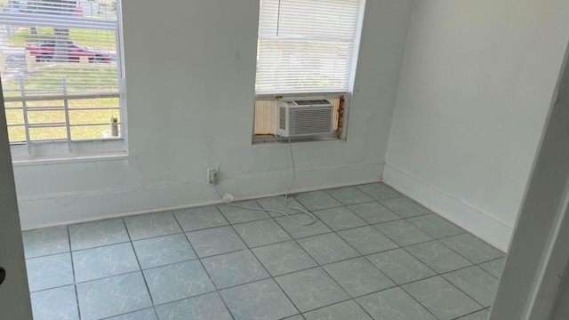 tiled spare room featuring plenty of natural light and cooling unit