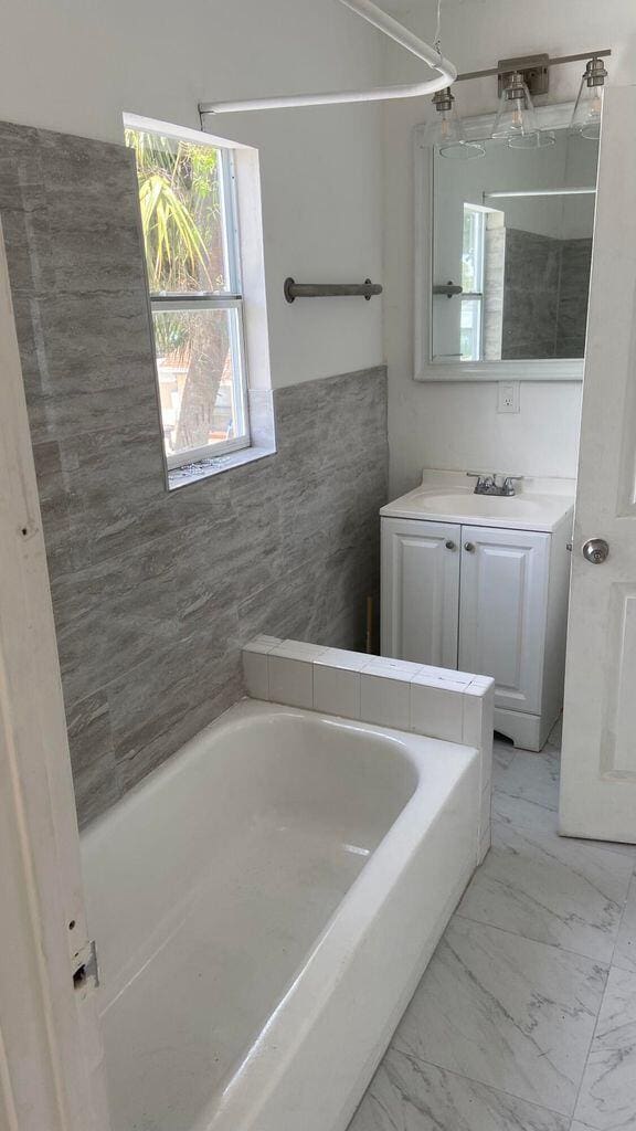 bathroom with vanity and a washtub