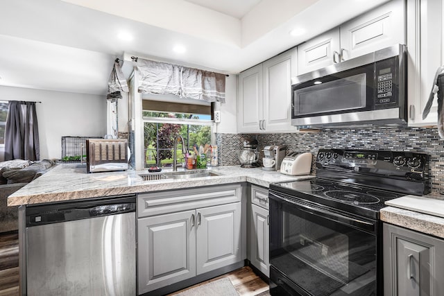 kitchen featuring sink, decorative backsplash, gray cabinets, and stainless steel appliances